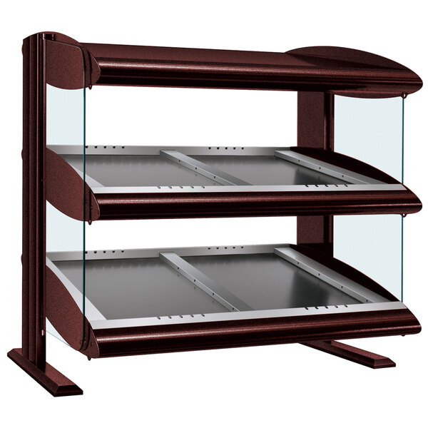 A Hatco heated zone merchandiser with double slanted glass shelves on a counter.