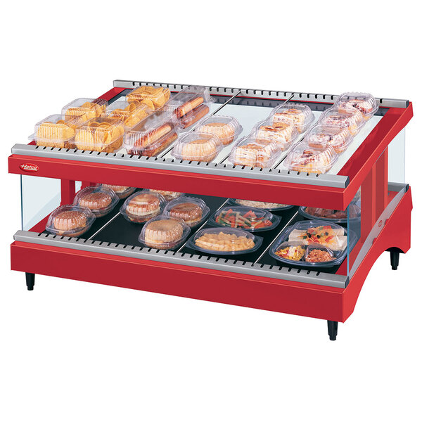 A Hatco red heated glass display case with food on a shelf.