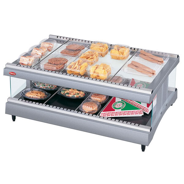 A Hatco heated glass display case with food on a shelf.