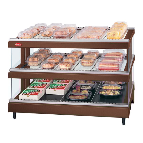A Hatco Antique Copper heated glass display case on a counter with food in it.