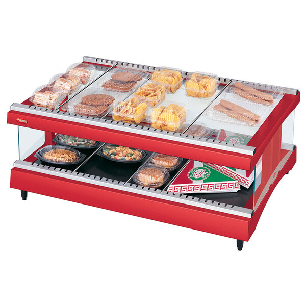 A Hatco warm red countertop display case with food on a shelf.