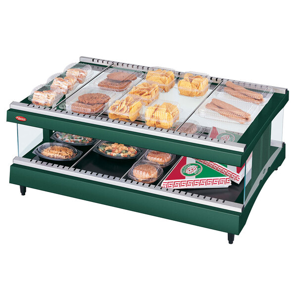 A Hunter Green Hatco heated glass display shelf on a counter with various food trays.