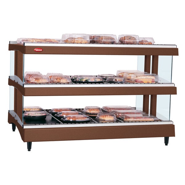 A Hatco countertop heated glass display case with food on shelves.