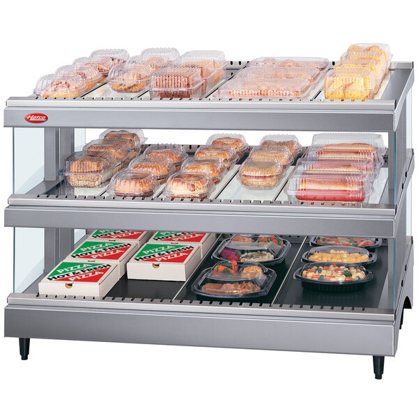 A Hatco Gray Granite Glo-Ray heated glass merchandising warmer with trays of food on shelves.