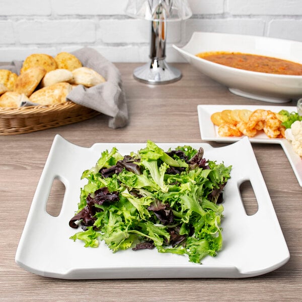 A white rectangular porcelain platter with salad and shrimp on it.