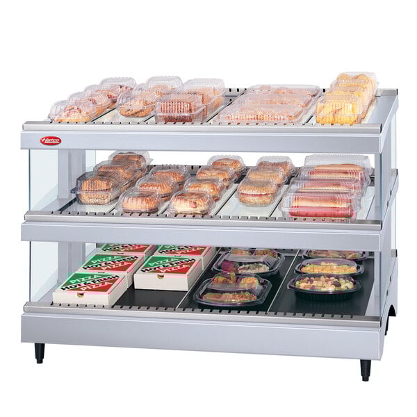A Hatco White Granite Glo-Ray heated glass display case with food on shelves.