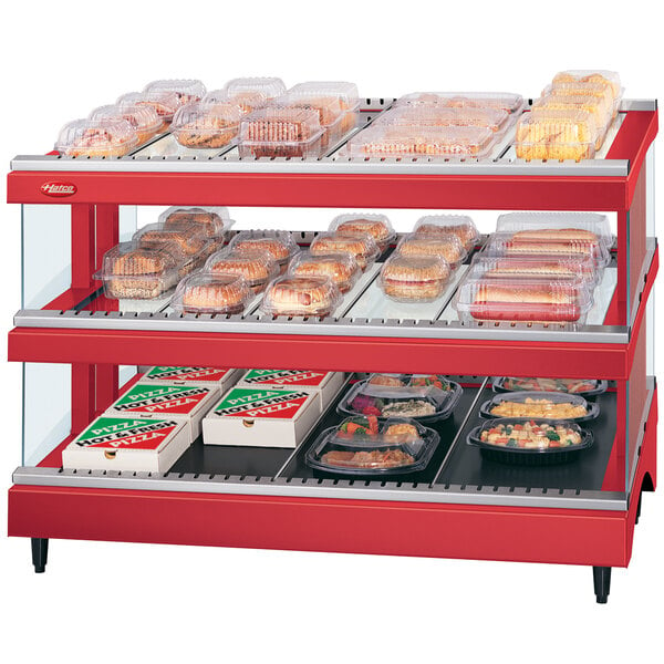 A red Hatco countertop food display warmer with shelves of food.