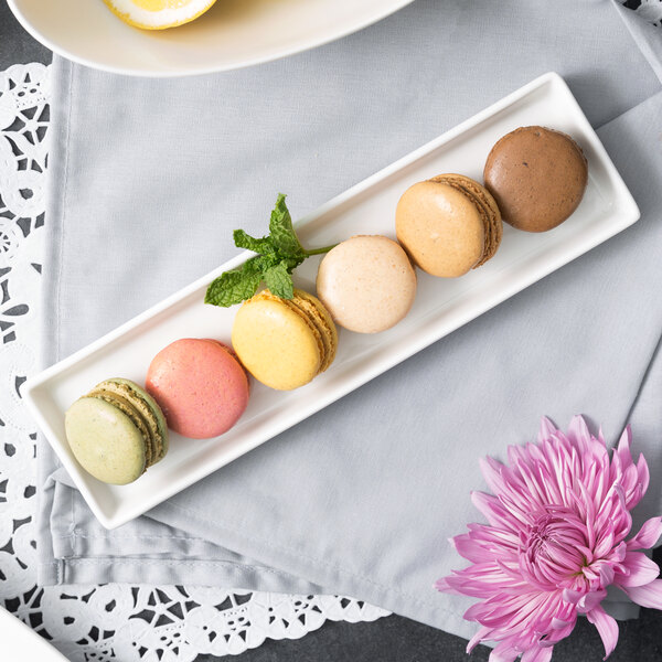 A white rectangular porcelain dish with a brown cookie and a lemon on it.