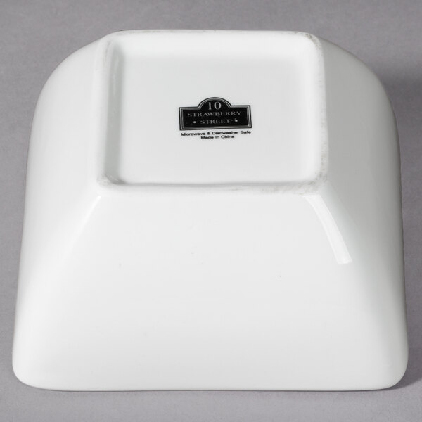 A white square bowl with a black label.