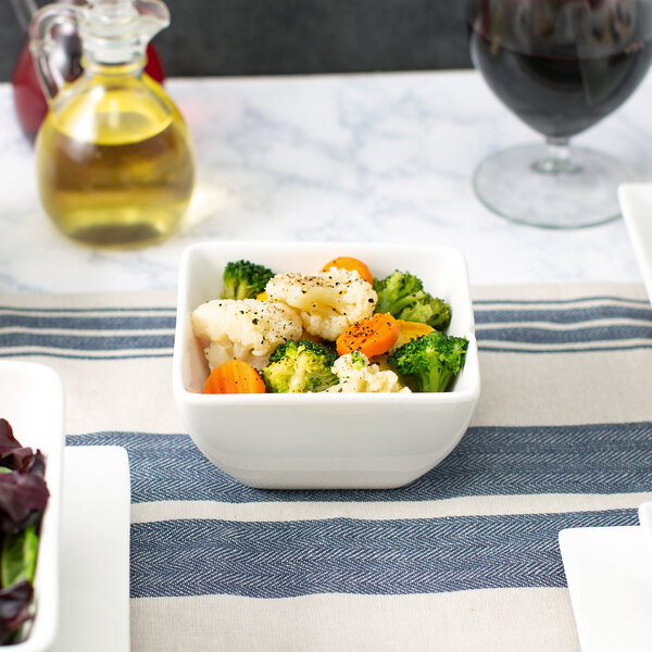 A bowl of vegetables in a 10 Strawberry Street white porcelain bowl on a table.