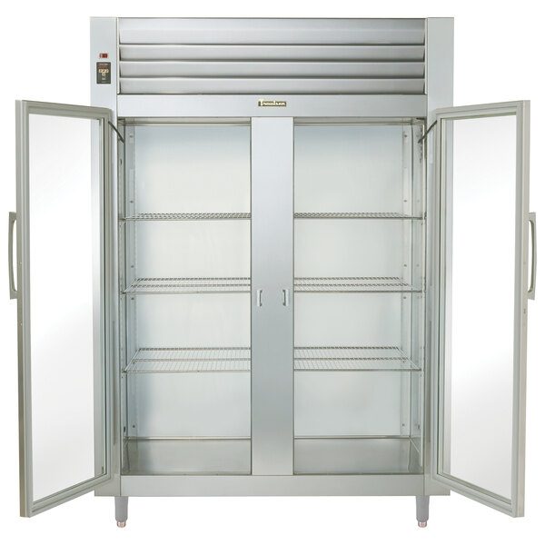 A Traulsen white refrigerator with glass doors and shelves.