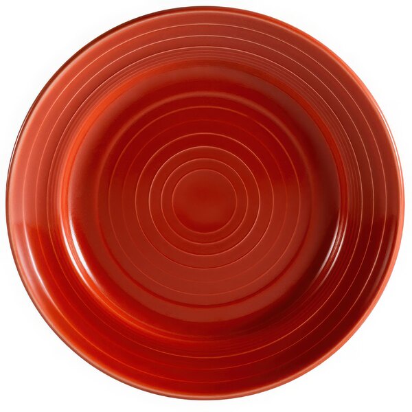 A red porcelain plate with a spiral pattern.