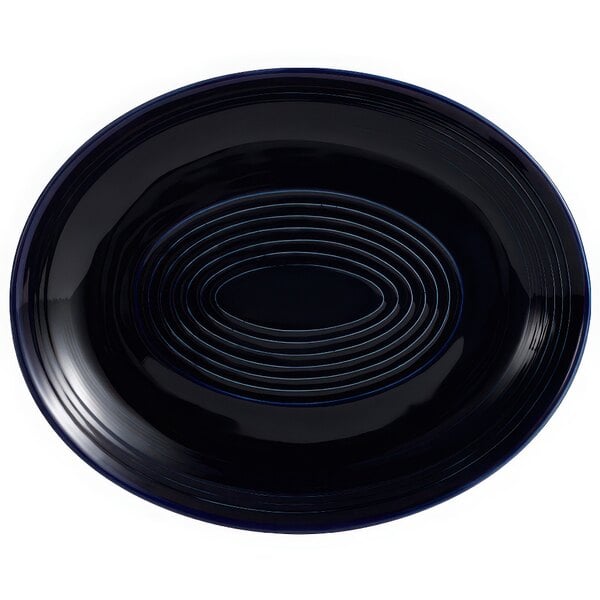 A black oval platter with a spiral pattern in cobalt blue.