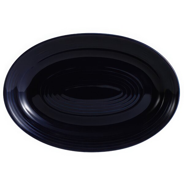 A black oval platter with a wavy pattern on the rim.