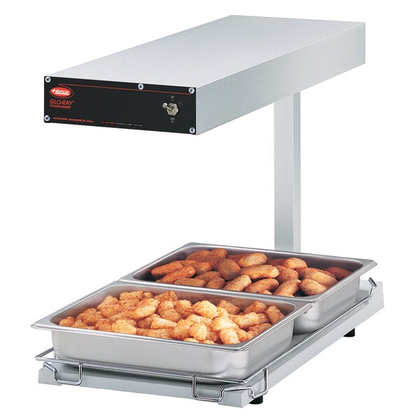 A Hatco portable food warmer with two trays of food on it.