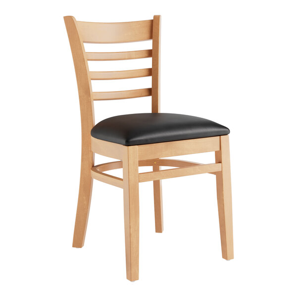 A Lancaster Table & Seating wooden restaurant chair with a black cushion on the seat and back.