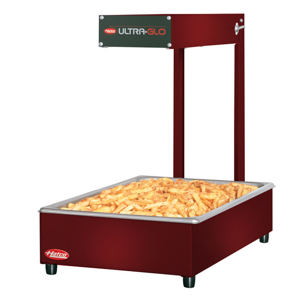 A red Hatco food warmer with french fries on top.