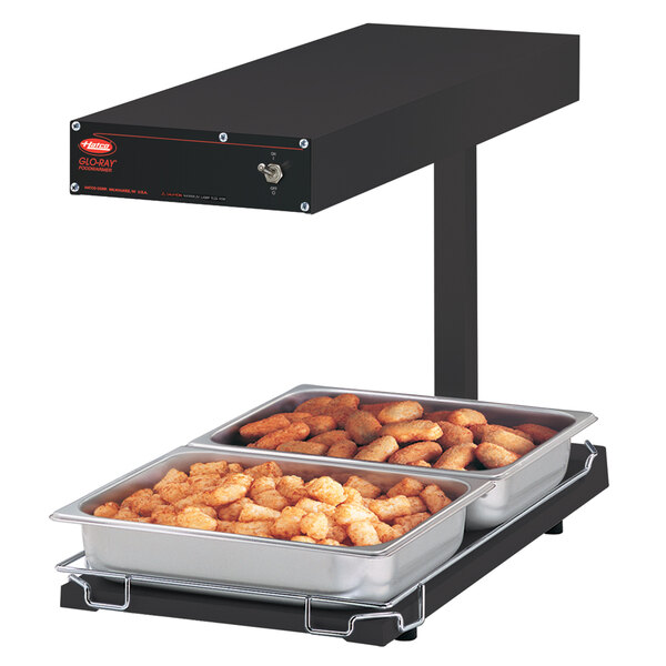 A Hatco Glo-Ray food warmer on a counter with two trays of food inside.