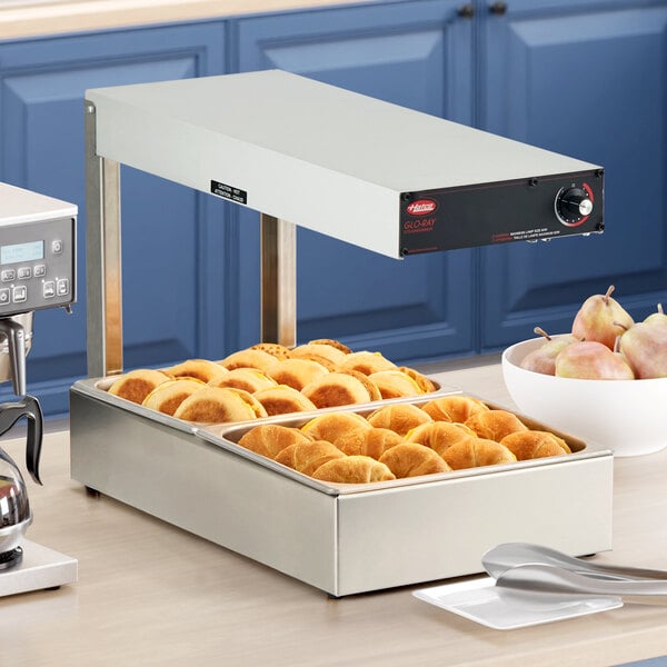 A Hatco Glo-Ray portable food warmer with trays of food on a counter.