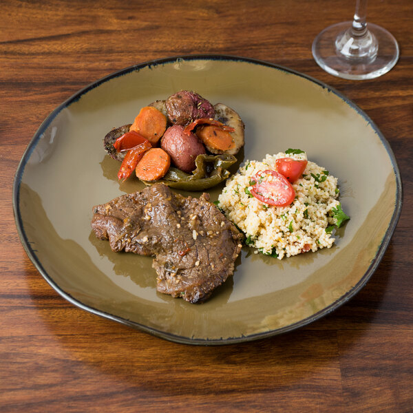 A TuxTrendz Artisan Mojave China plate with meat and vegetables on a table.