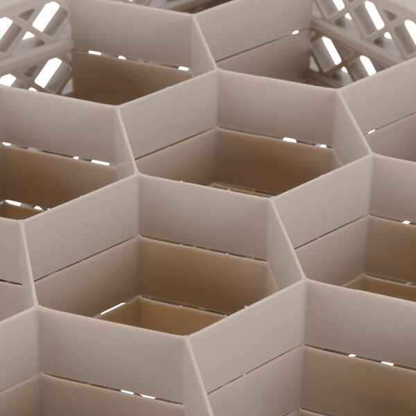 A white Vollrath Traex glass rack with hexagonal compartments.