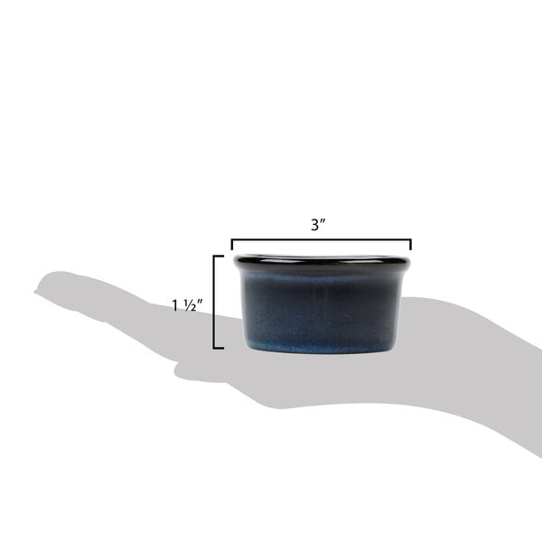 A hand holding a Tuxton TuxTrendz Artisan Night Sky blue china ramekin.