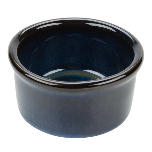 A blue ceramic Tuxton ramekin with a black rim.