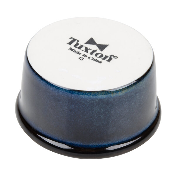 A blue and white ceramic Tuxton ramekin on a table.