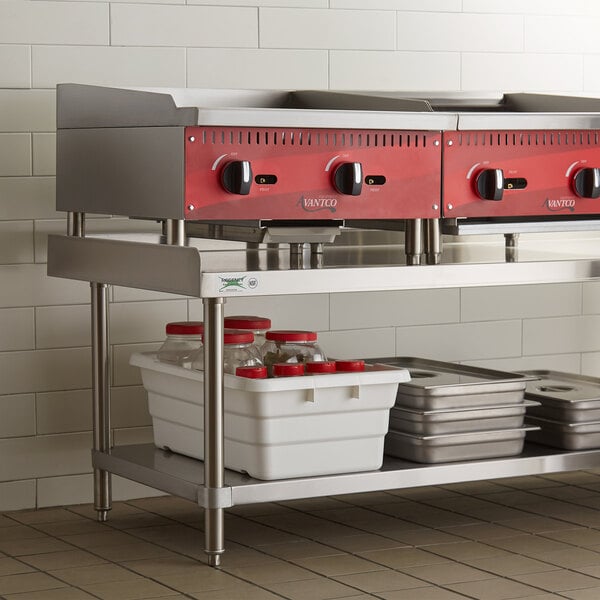 A Regency stainless steel equipment stand with a white container and red lids on it.