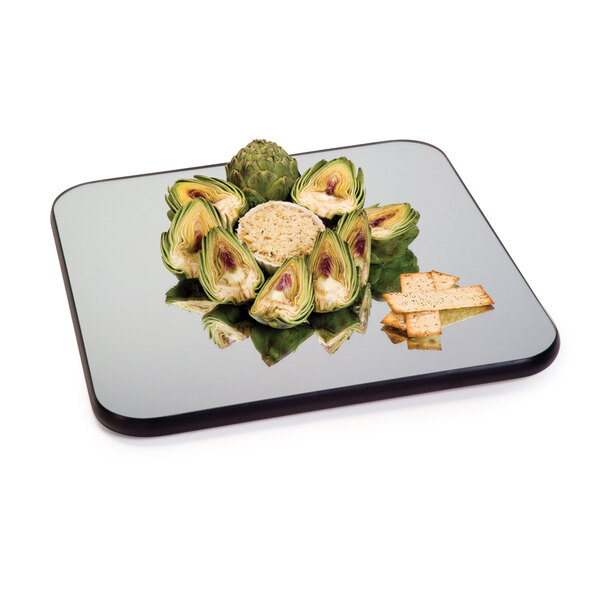 A Geneva square rimless mirror food display tray with artichokes and crackers on it.