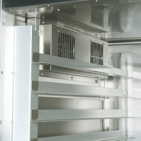 A Traulsen stainless steel pass-through refrigerator with shelves and doors.