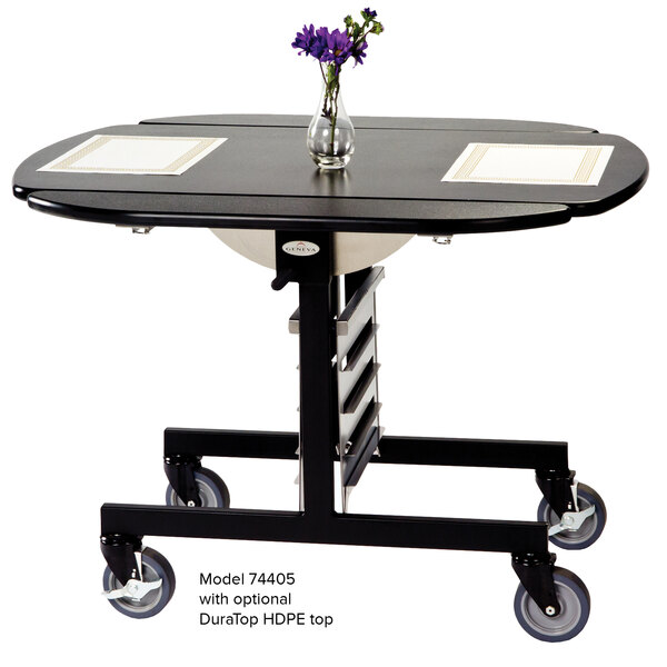 A Geneva room service table with a gray sand top and stainless steel frame, with a vase of flowers on it.
