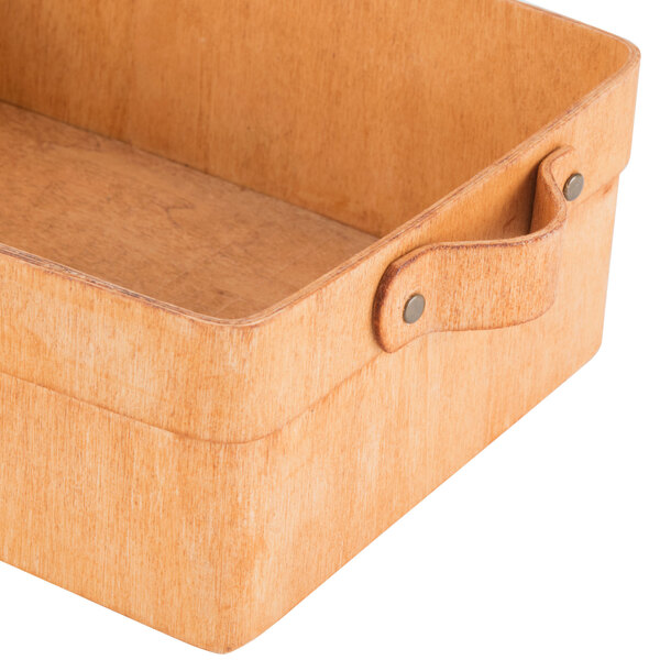 A rectangular poplar wood basket with handles on a counter.