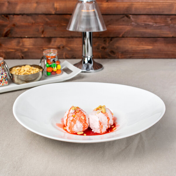 A white oval porcelain bowl filled with food on a table.