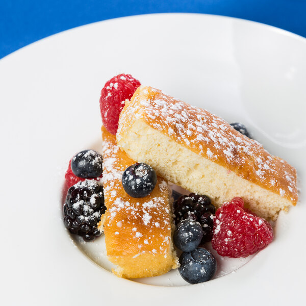 A 10 Strawberry Street Whittier white porcelain plate topped with cake and berries.