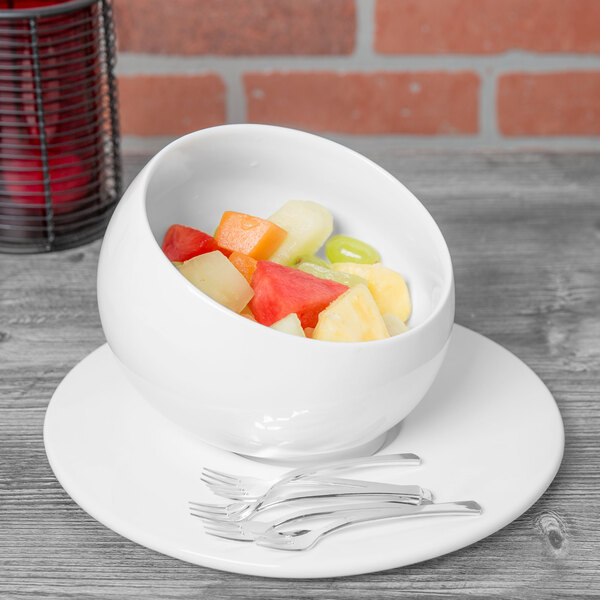 A bowl of fruit on a white 10 Strawberry Street Whittier porcelain plate.