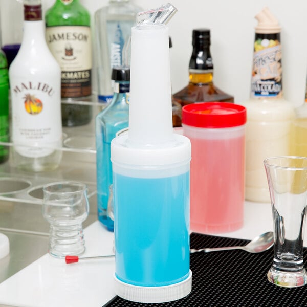 A close up of a white Carlisle Store 'N Pour container with a white spout and cap on a counter.