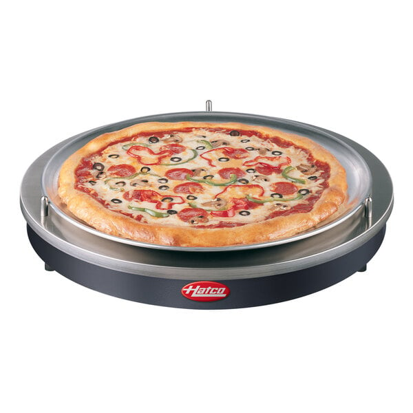 A pizza on a Hatco heated shelf over a black base.