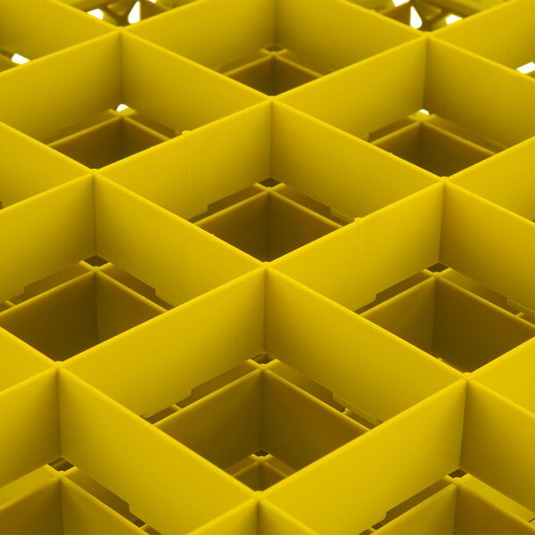 A yellow Vollrath Traex glass rack with square compartments.