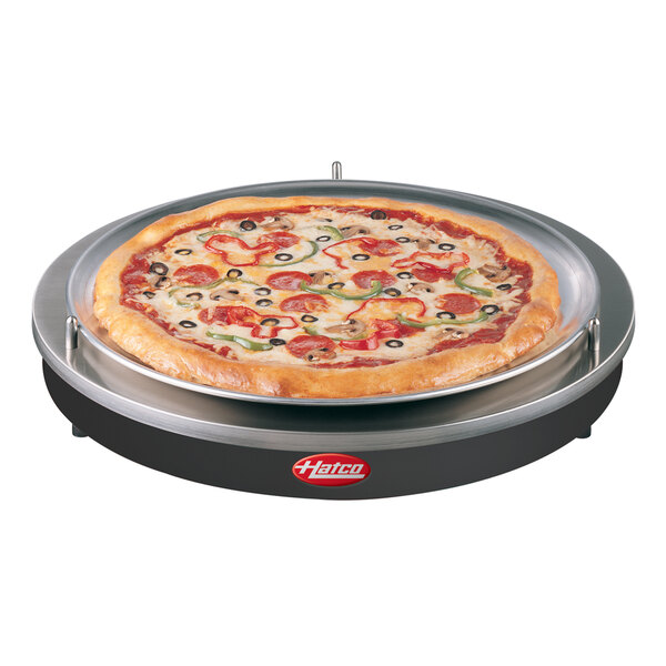 A pizza on a Hatco heated shelf in a pizza parlor.