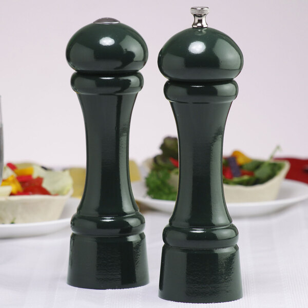 Two green Chef Specialties pepper grinders on a table.