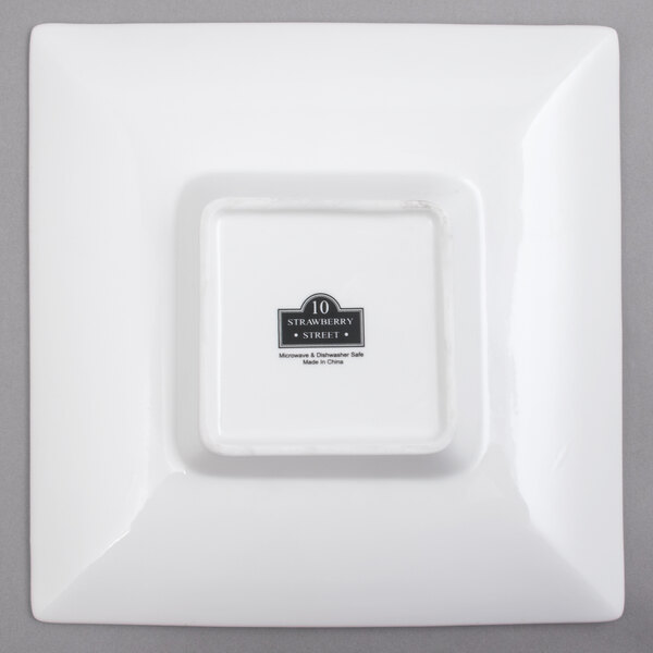 A white square porcelain bowl with a square white object in the middle.