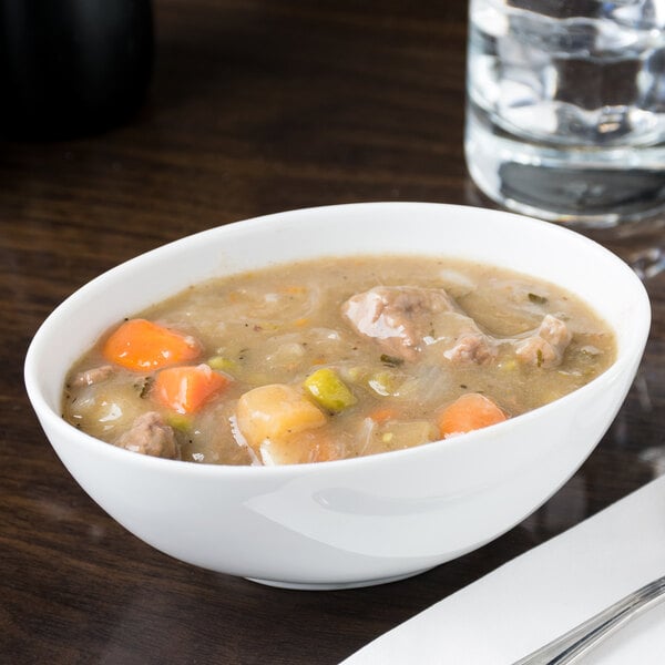 A white 10 Strawberry Street Royal porcelain bowl filled with stew with meat and vegetables.