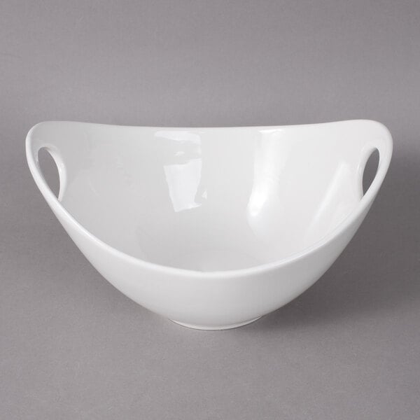 A close-up of a 10 Strawberry Street Whittier white porcelain bowl with a curved edge and cut outs.