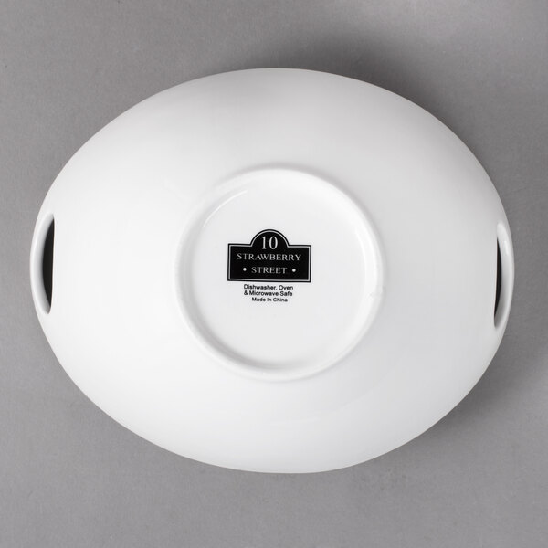 A white porcelain bowl with a curved cut out design.