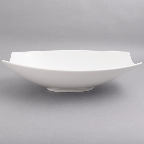A close up of a white 10 Strawberry Street Whittier rectangular samurai bowl with curved edges.