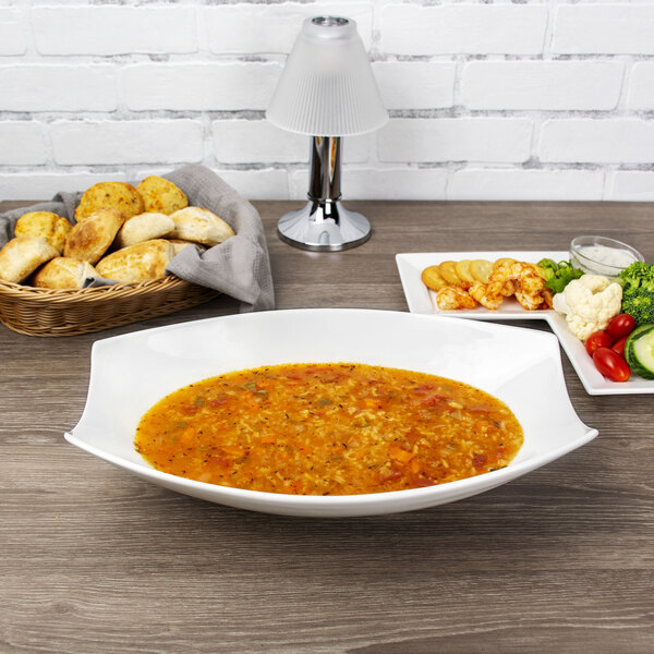 A 10 Strawberry Street Whittier porcelain rectangular bowl of soup next to a plate of food.