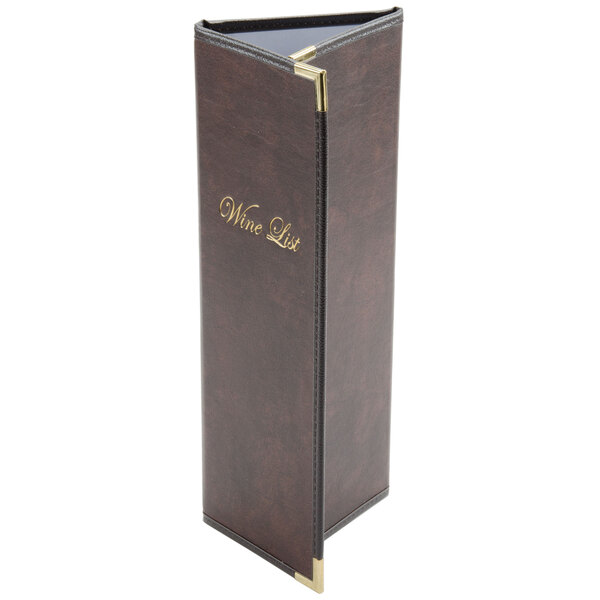 A brown leather Menu Solutions Royal Select menu cover with gold trim on a table in a winery cellar.