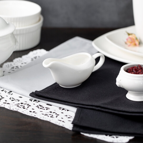 A white 10 Strawberry Street porcelain gravy boat on a black surface.