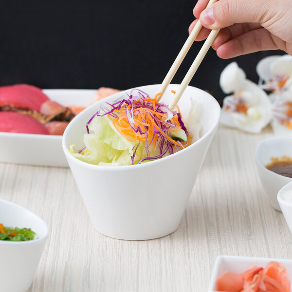 A person holding chopsticks over a bowl of food.